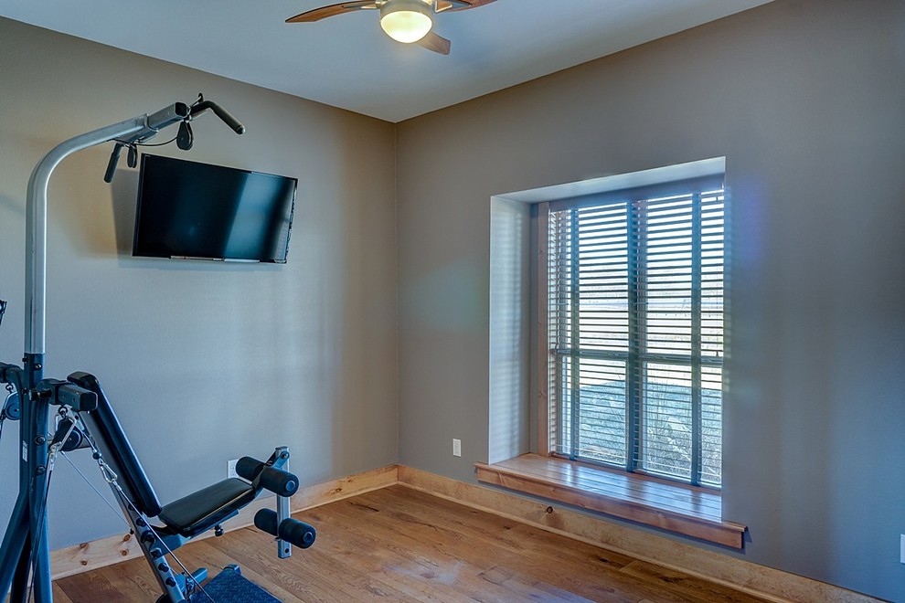 Multifunktionaler, Mittelgroßer Landhausstil Fitnessraum mit grauer Wandfarbe und braunem Holzboden in Dallas