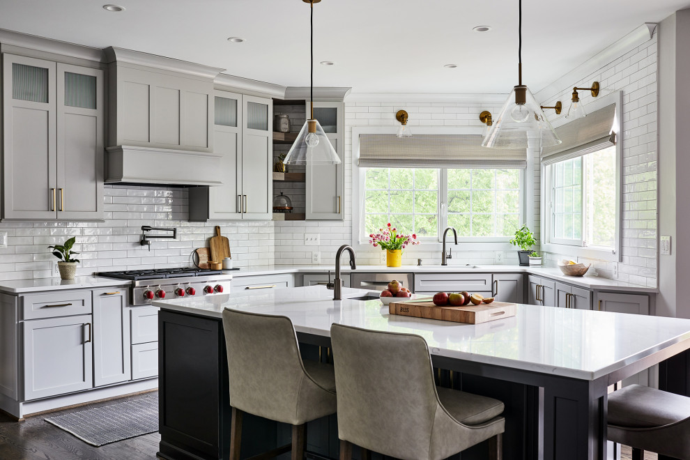 Transitional u-shaped dark wood floor and brown floor kitchen photo in Boston with an undermount sink, shaker cabinets, gray cabinets, white backsplash, subway tile backsplash, stainless steel appliances, an island and white countertops