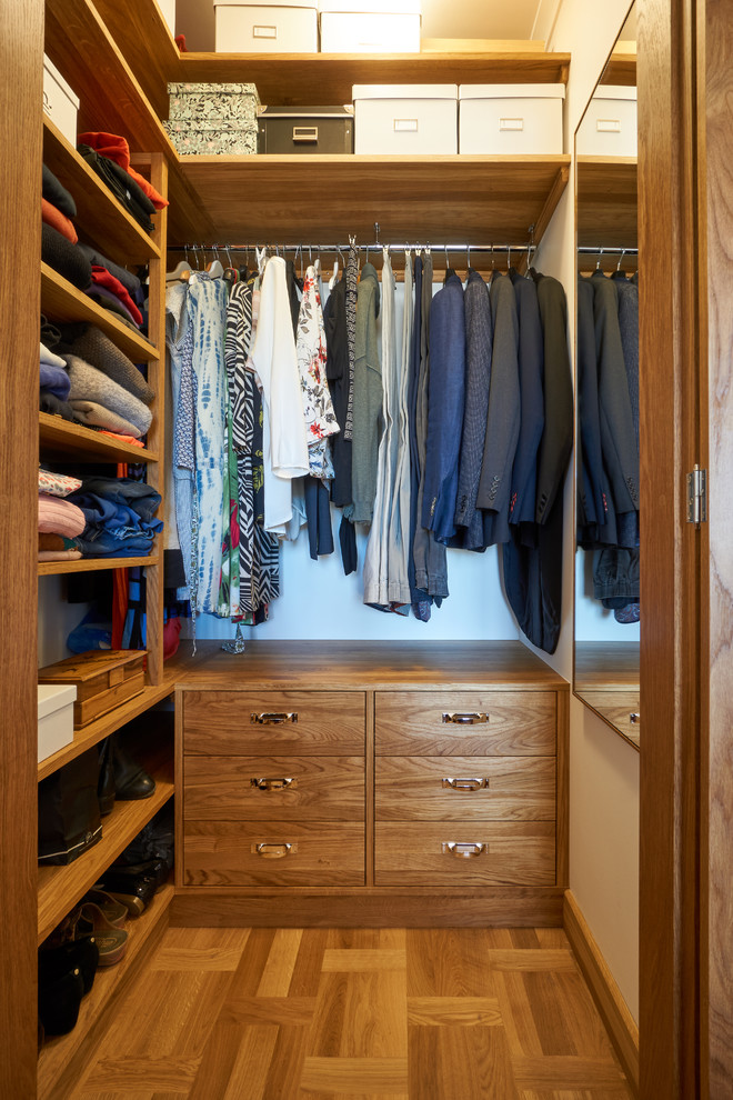 Inspiration for a small midcentury gender-neutral walk-in wardrobe in Stockholm with open cabinets, medium wood cabinets and medium hardwood floors.