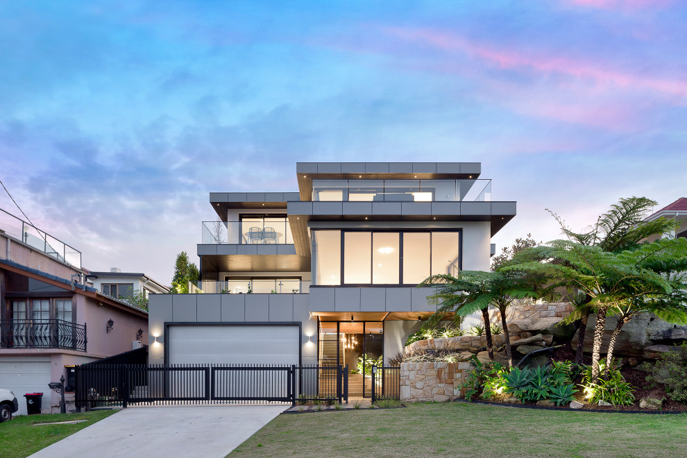 Contemporary three-storey grey house exterior in Sunshine Coast with a flat roof and a grey roof.