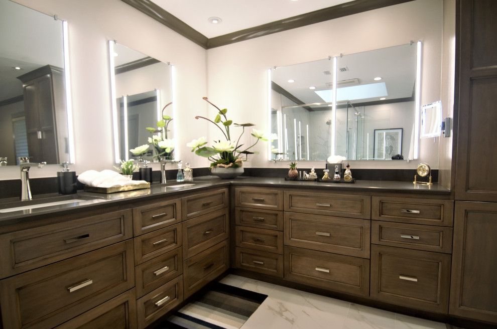 Photo of a mid-sized transitional master bathroom in Houston with recessed-panel cabinets, medium wood cabinets, a corner shower, a one-piece toilet, white tile, porcelain tile, white walls, porcelain floors, an undermount sink, solid surface benchtops, white floor, a hinged shower door, brown benchtops, a shower seat, a double vanity and a built-in vanity.