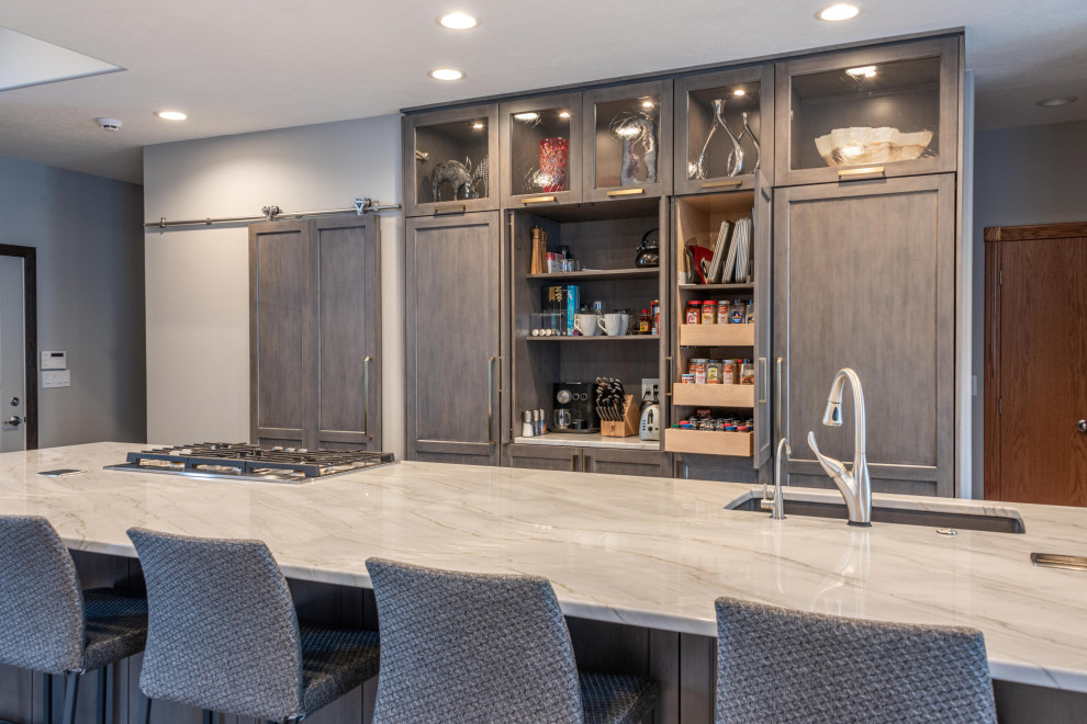 Kitchen - large transitional medium tone wood floor and brown floor kitchen idea with a single-bowl sink, flat-panel cabinets, gray cabinets, quartzite countertops, gray backsplash, marble backsplash, paneled appliances, an island and white countertops