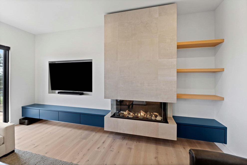 This is an example of a small modern open concept living room in Toronto with grey walls, light hardwood floors, a hanging fireplace, a built-in media wall and beige floor.