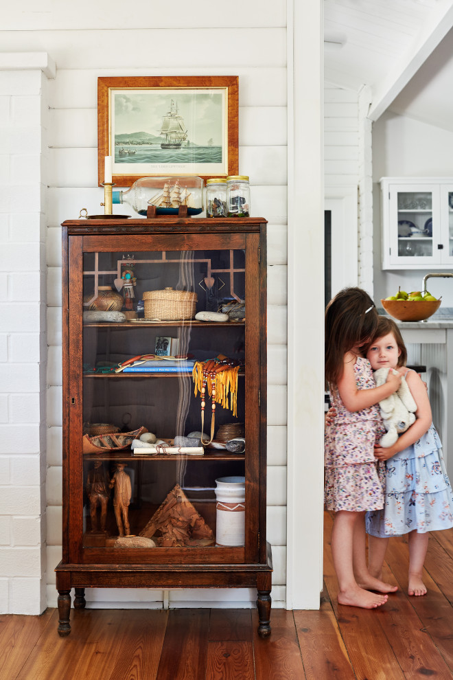 Mid-sized farmhouse medium tone wood floor, brown floor and shiplap wall enclosed dining room photo in Toronto with white walls