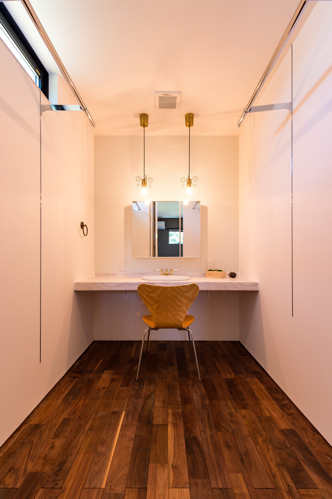 Photo of a modern powder room in Other with white walls, dark hardwood floors, a drop-in sink, marble benchtops and brown floor.
