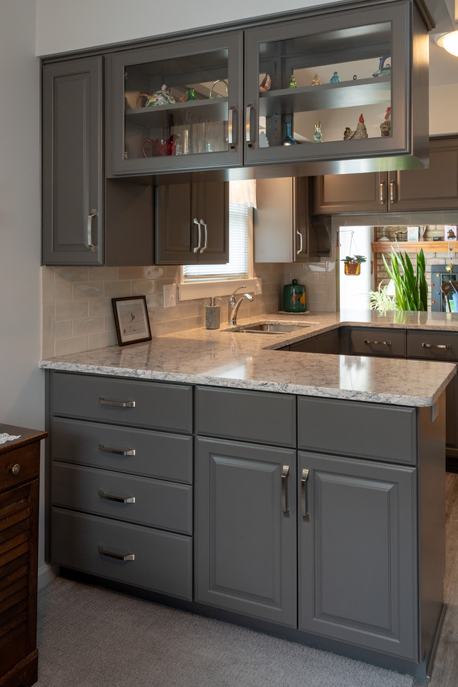 Example of a small transitional u-shaped vinyl floor and gray floor eat-in kitchen design with a double-bowl sink, raised-panel cabinets, gray cabinets, quartz countertops, white backsplash, subway tile backsplash, white appliances, no island and multicolored countertops