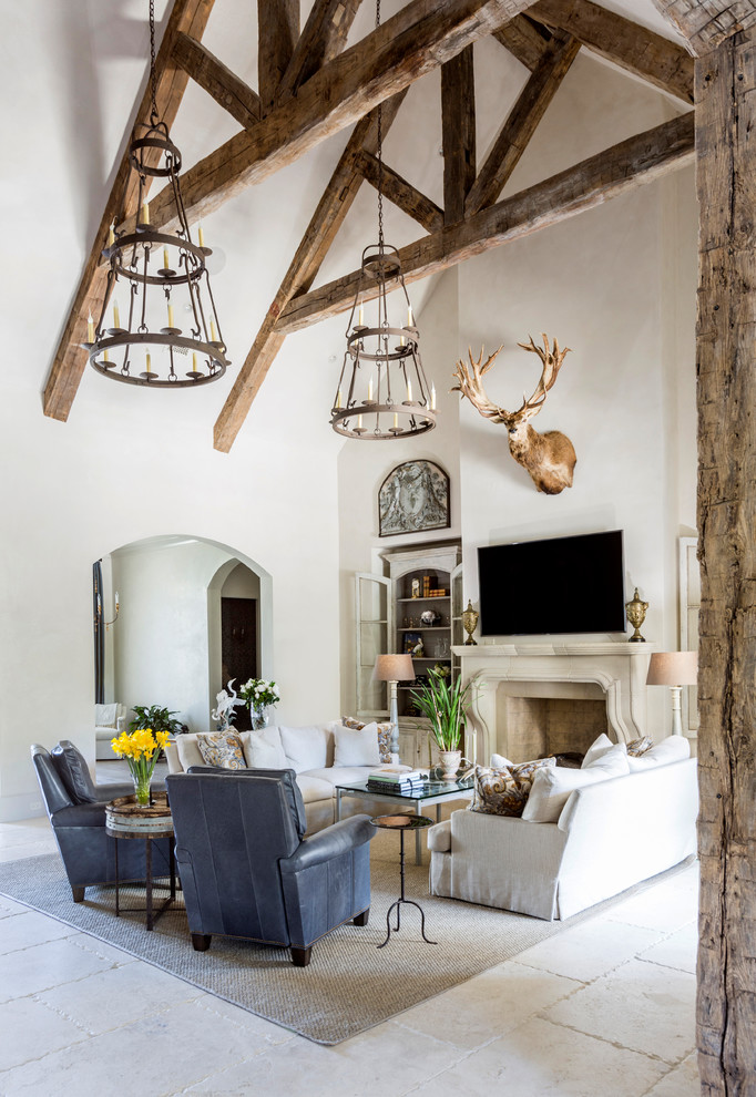 Country living room in Houston with beige walls, a standard fireplace, a stone fireplace surround, a wall-mounted tv and beige floor.