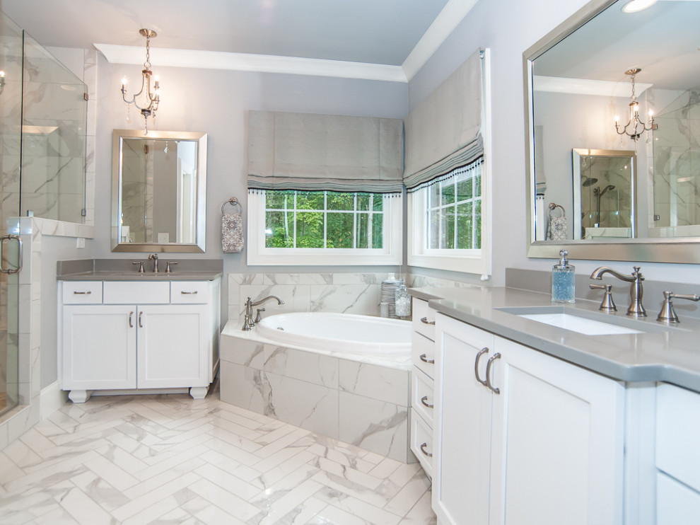 Design ideas for a large contemporary master bathroom in Raleigh with shaker cabinets, white cabinets, a corner tub, gray tile, porcelain tile, grey walls, an undermount sink, a hinged shower door and grey benchtops.