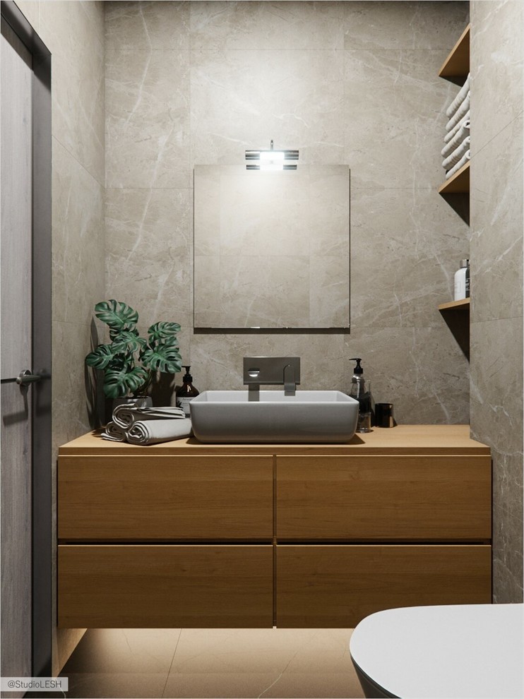 Inspiration for a small scandinavian powder room in Saint Petersburg with flat-panel cabinets, brown cabinets, a wall-mount toilet, brown tile, ceramic tile, brown walls, ceramic floors, a drop-in sink, wood benchtops, black floor and brown benchtops.