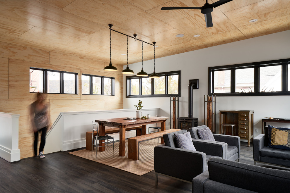 Réalisation d'une salle à manger urbaine en bois avec un mur blanc, un sol en vinyl, un poêle à bois, un sol gris et un plafond en bois.