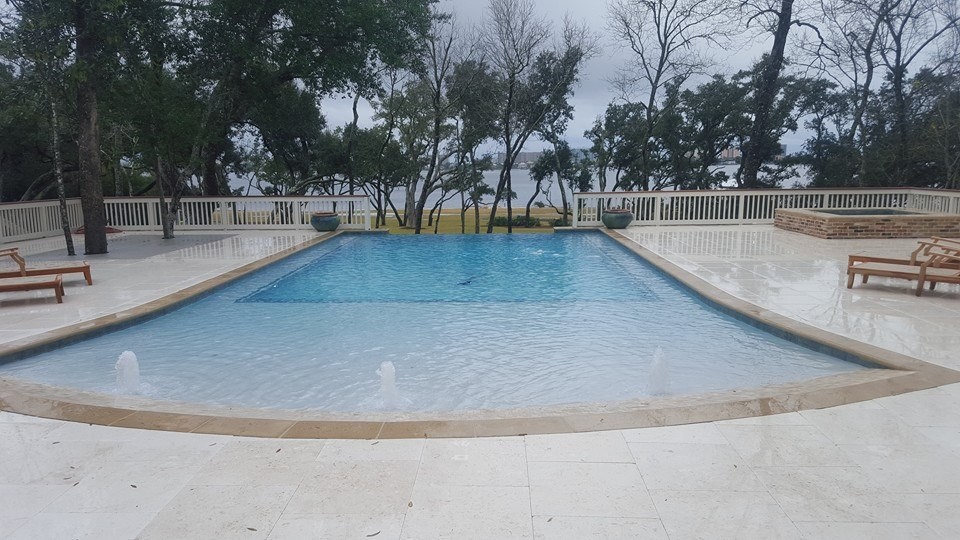 Mid-sized transitional backyard concrete paver and rectangular infinity pool fountain photo in Miami