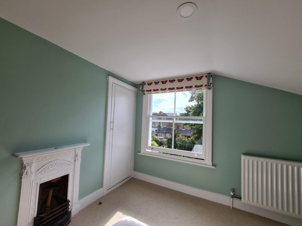 Réalisation d'une chambre tradition de taille moyenne avec un mur vert, une cheminée standard, un manteau de cheminée en métal, un sol beige et un plafond décaissé.