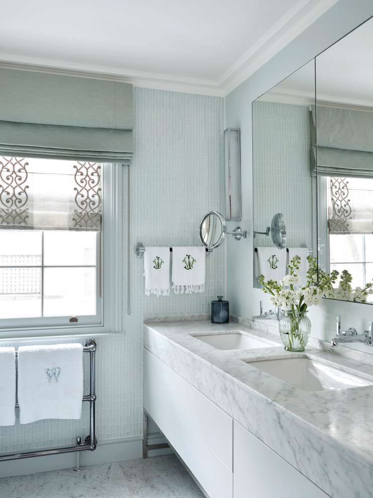 Идея дизайна: ванная комната в стиле неоклассика (современная классика) с плоскими фасадами, белыми фасадами, синей плиткой, плиткой мозаикой, синими стенами, врезной раковиной, белым полом, белой столешницей, тумбой под две раковины и напольной тумбой