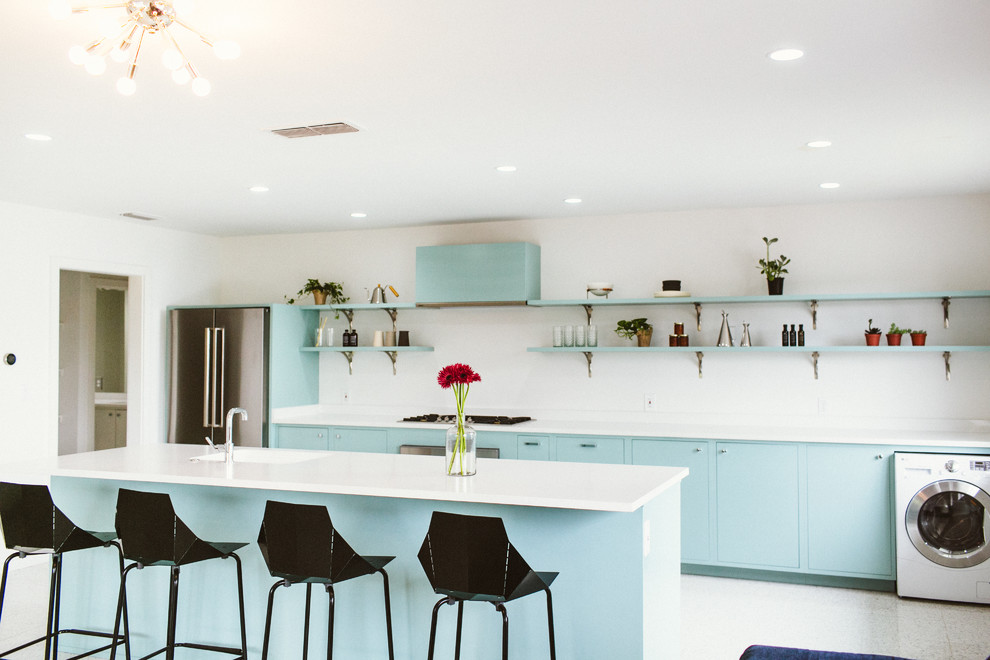 Modern single-wall eat-in kitchen in Austin with an undermount sink, flat-panel cabinets, blue cabinets, quartz benchtops, white splashback, engineered quartz splashback, stainless steel appliances, terrazzo floors, with island, white floor, white benchtop and recessed.