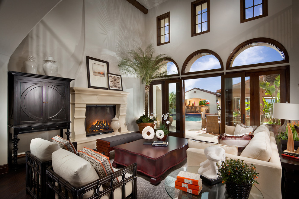 Design ideas for an expansive mediterranean formal open concept living room in San Diego with beige walls, dark hardwood floors, a standard fireplace, a plaster fireplace surround and no tv.