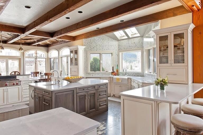 Example of a mid-sized transitional single-wall concrete floor kitchen design with a farmhouse sink, flat-panel cabinets, white cabinets, quartz countertops, white backsplash, marble backsplash and stainless steel appliances