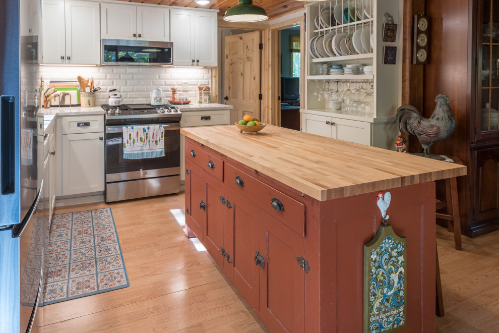 This is an example of a small eclectic l-shaped eat-in kitchen in Minneapolis with an undermount sink, shaker cabinets, white cabinets, quartz benchtops, white splashback, subway tile splashback, stainless steel appliances, laminate floors, with island, beige floor and beige benchtop.