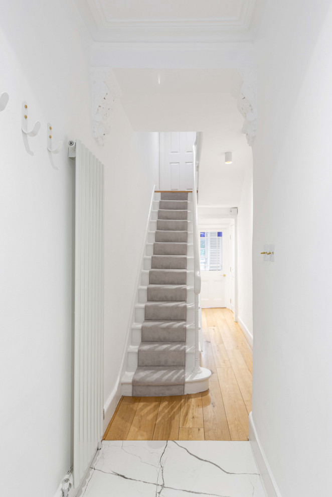 Foto di un ingresso o corridoio minimalista di medie dimensioni con pareti bianche, pavimento in gres porcellanato e pavimento bianco