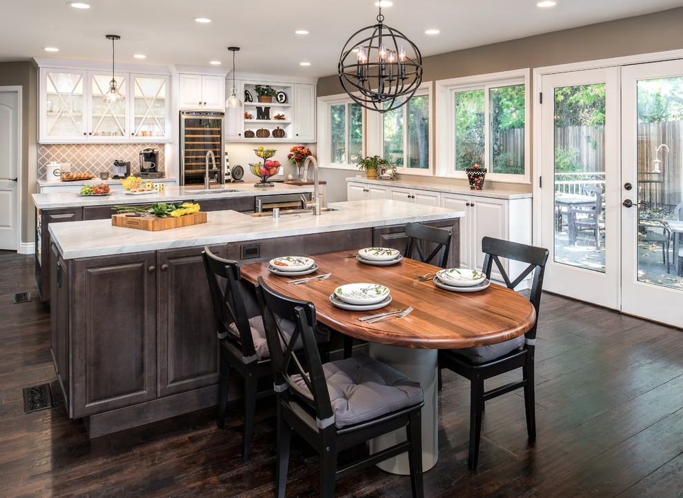 This is an example of a large traditional kitchen in Sacramento with white cabinets, marble benchtops, dark hardwood floors, multiple islands, glass-front cabinets and multi-coloured splashback.