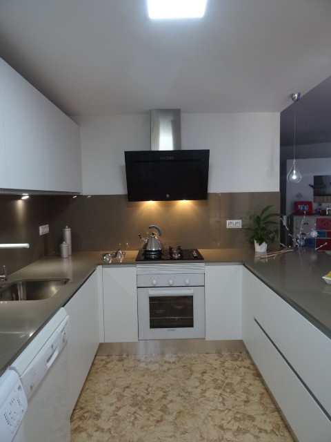 Modern u-shaped open plan kitchen in Alicante-Costa Blanca with an undermount sink and quartz benchtops.