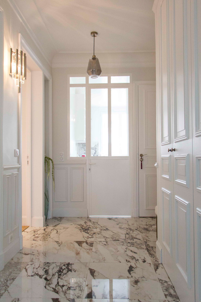 Large traditional foyer in Paris with white walls, ceramic flooring and white floors.