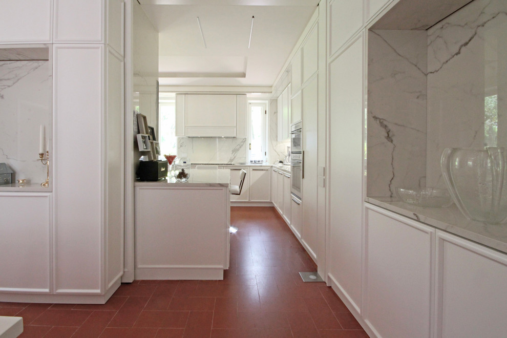 Design ideas for an expansive traditional eat-in kitchen in Milan with recessed-panel cabinets, marble benchtops, white appliances, ceramic floors, with island, red floor and white benchtop.