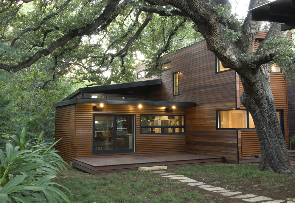 Photo of a large modern two-storey brown exterior in Austin with wood siding and a flat roof.