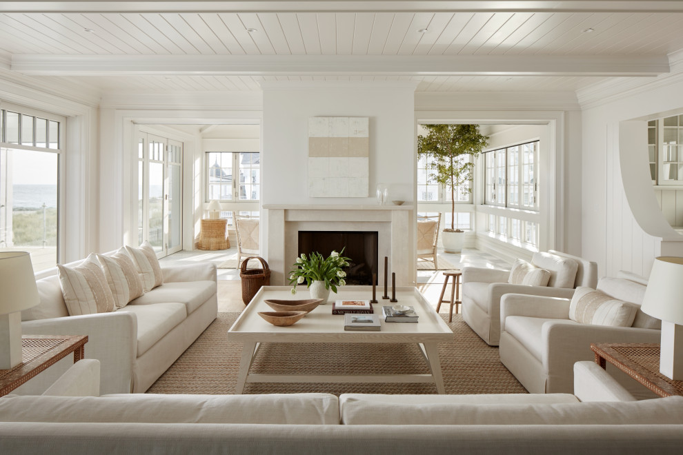 Offenes Maritimes Wohnzimmer mit weißer Wandfarbe, braunem Holzboden, Kamin, braunem Boden, freigelegten Dachbalken und Holzdielendecke in Philadelphia