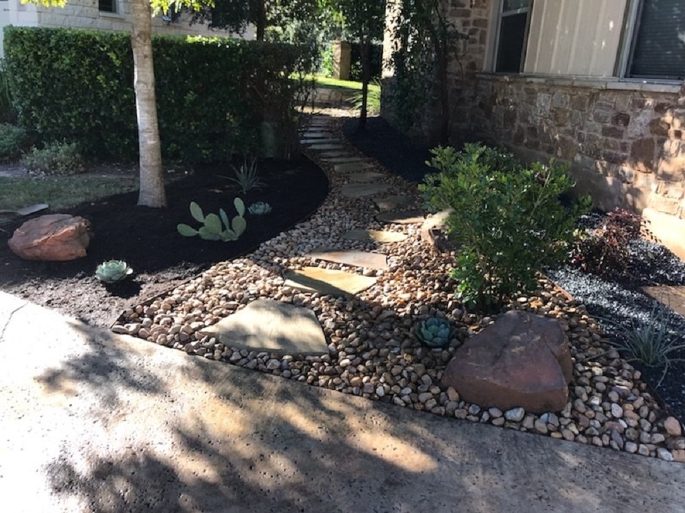 Inspiration for a mid-sized modern side yard partial sun xeriscape in Austin with a garden path and natural stone pavers.