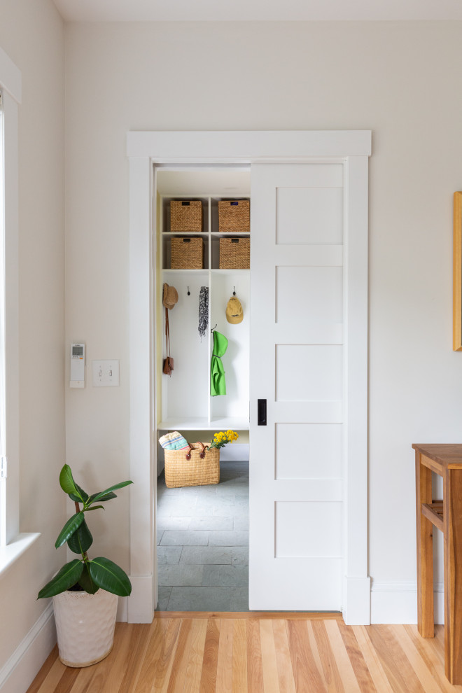 Идея дизайна: тамбур в стиле неоклассика (современная классика) с желтыми стенами, полом из сланца, одностворчатой входной дверью, белой входной дверью и зеленым полом