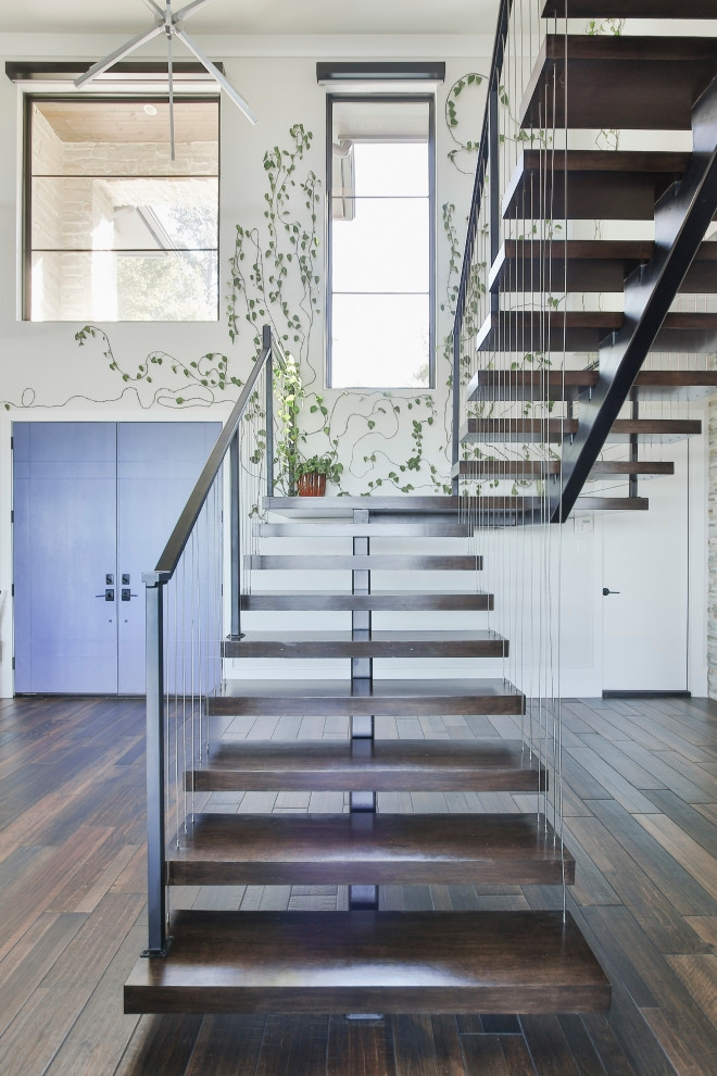 Photo of a mid-sized contemporary wood floating staircase in Houston with wood risers and wood railing.