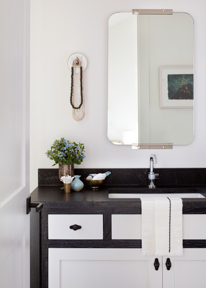 Bild på ett litet lantligt svart svart badrum, med släta luckor, svarta skåp, vit kakel, vita väggar, ett undermonterad handfat och granitbänkskiva