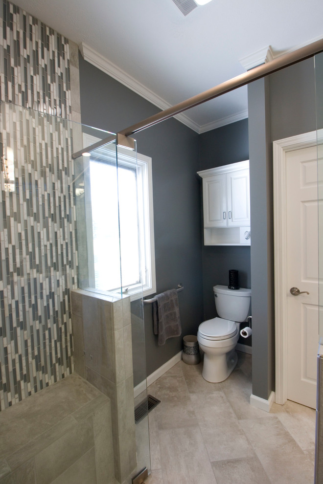 Walk-in shower - mid-sized transitional master gray tile and ceramic tile ceramic tile walk-in shower idea with an undermount sink, raised-panel cabinets, white cabinets, granite countertops, a two-piece toilet and gray walls