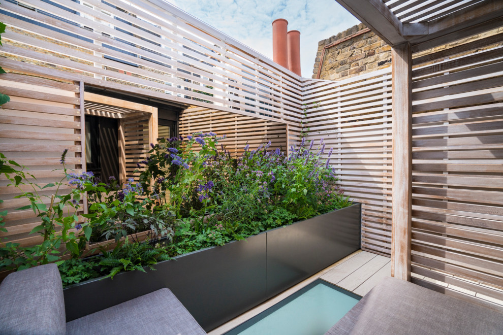 Kleine Nordische Terrasse im Dach mit Kübelpflanzen und Holzgeländer in London