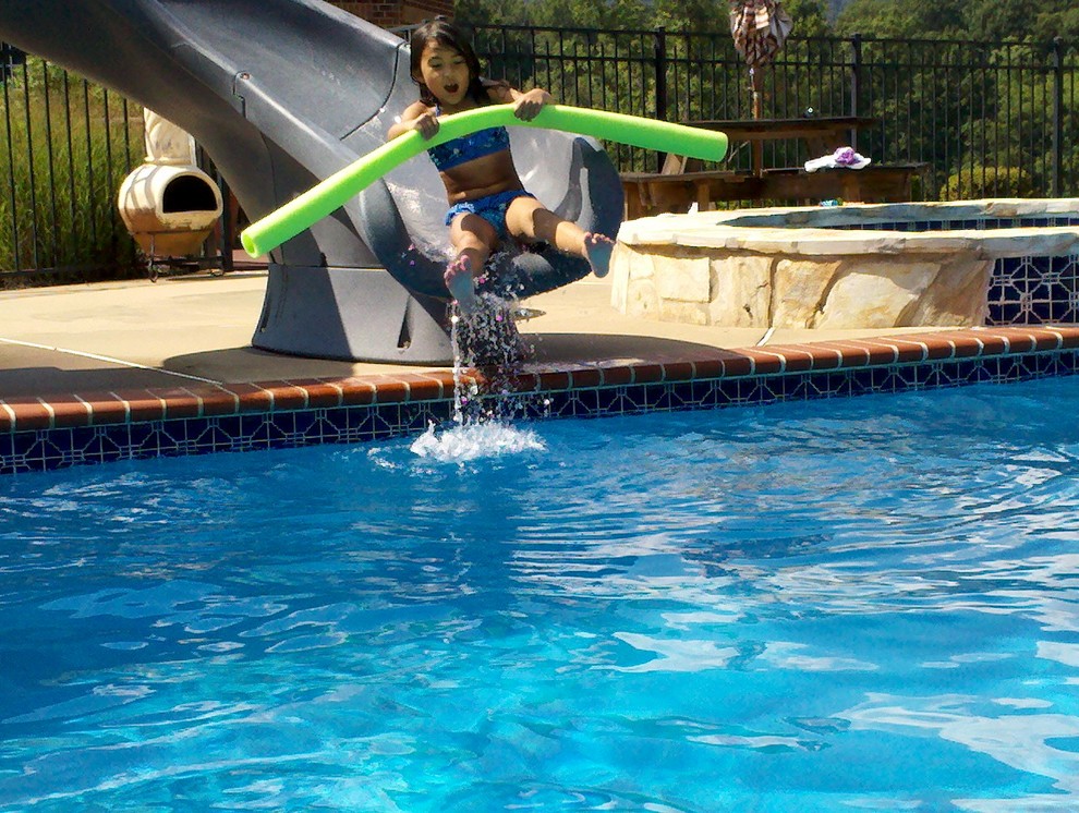 Example of a mid-sized backyard concrete paver pool fountain design in DC Metro