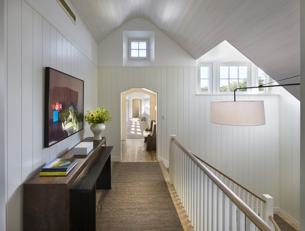 Photo of a mid-sized beach style hallway in Boston with white walls and medium hardwood floors.