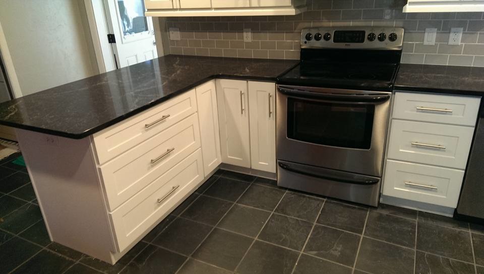 Eat-in kitchen - mid-sized transitional u-shaped ceramic tile and black floor eat-in kitchen idea in Miami with shaker cabinets, white cabinets, laminate countertops, gray backsplash, stainless steel appliances, a peninsula, an undermount sink, subway tile backsplash and black countertops