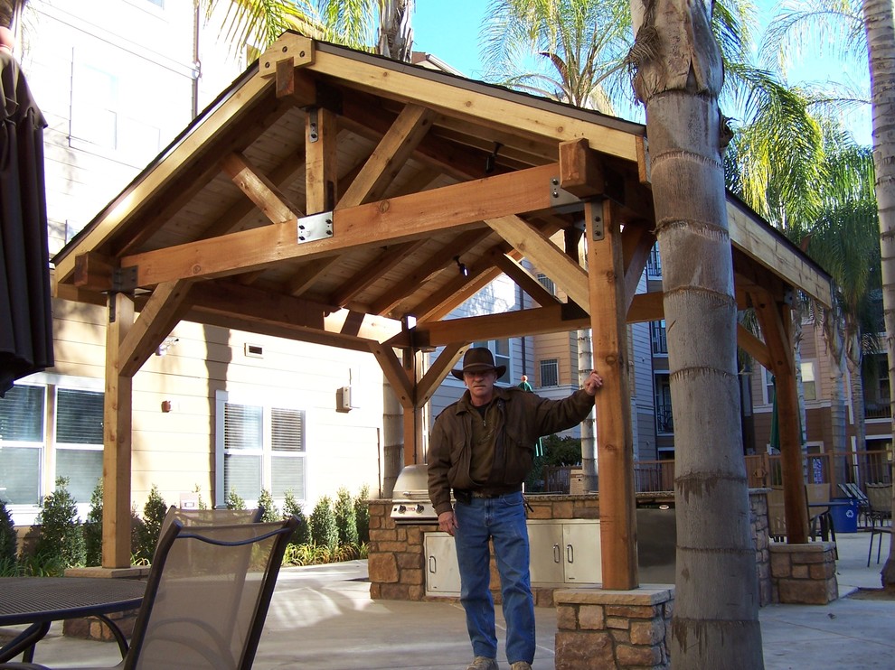 Example of a mid-sized arts and crafts backyard concrete patio design with a fire pit and a gazebo