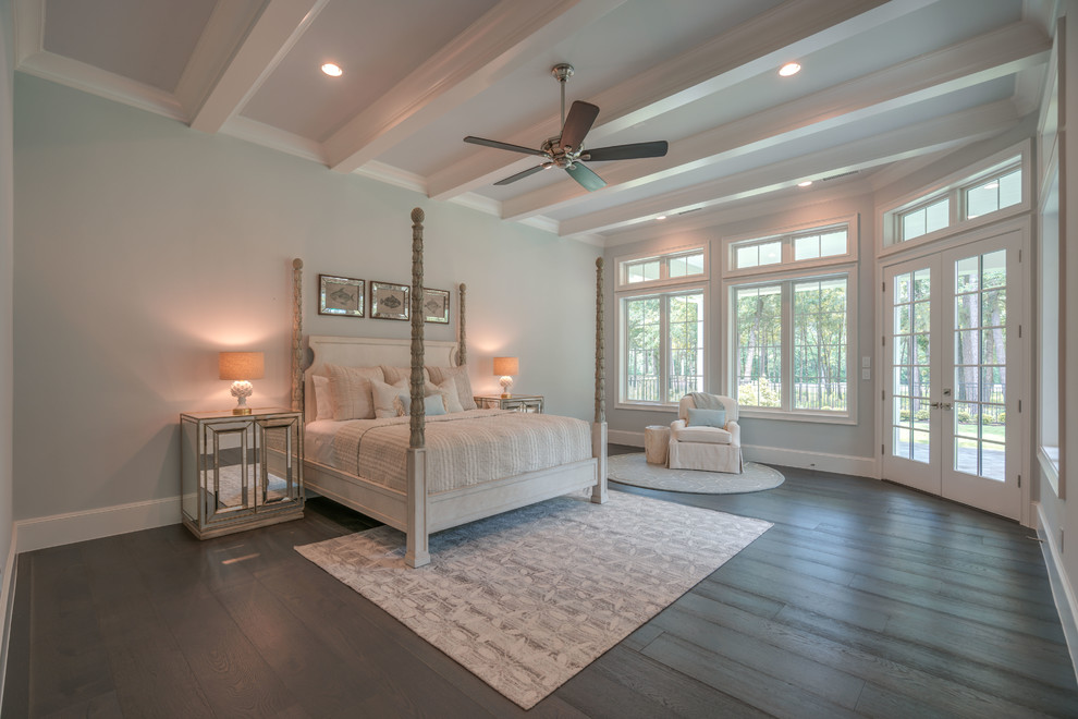 Photo of a large beach style master bedroom in Houston with blue walls, dark hardwood floors, brown floor, no fireplace and exposed beam.