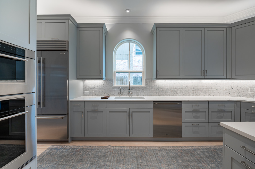 Inspiration for a large transitional u-shaped light wood floor and beige floor eat-in kitchen remodel in Houston with an undermount sink, shaker cabinets, gray cabinets, quartz countertops, ceramic backsplash, stainless steel appliances and white countertops