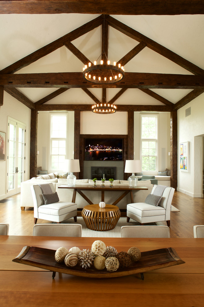Design ideas for an expansive country open concept family room in New York with medium hardwood floors, a standard fireplace, a stone fireplace surround and a wall-mounted tv.