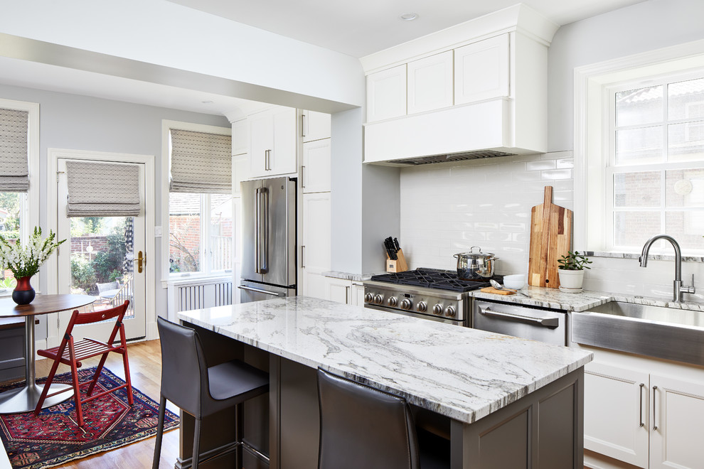 Photo of a transitional l-shaped kitchen in DC Metro with recessed-panel cabinets, white cabinets, granite benchtops and white splashback.