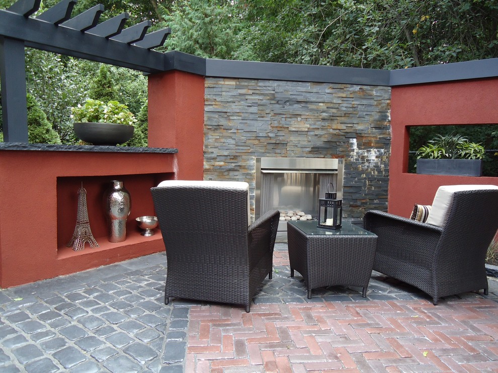 Mid-sized contemporary backyard patio in Toronto with a fire feature, brick pavers and no cover.