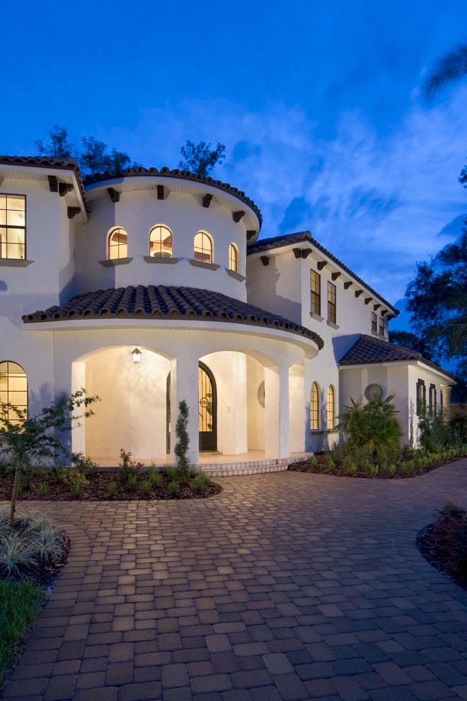 This is an example of a mediterranean stucco exterior in Orlando with a tile roof.