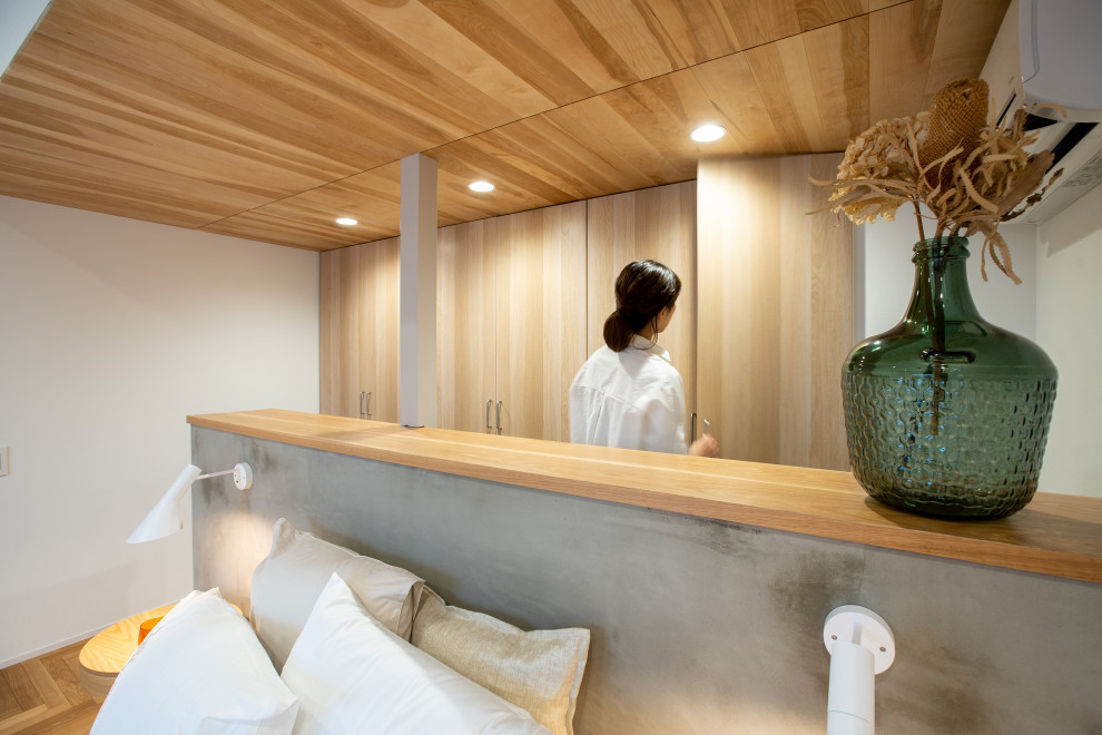 EIngebautes, Neutrales Shabby-Chic Ankleidezimmer mit hellen Holzschränken, braunem Holzboden und Holzdecke in Sonstige