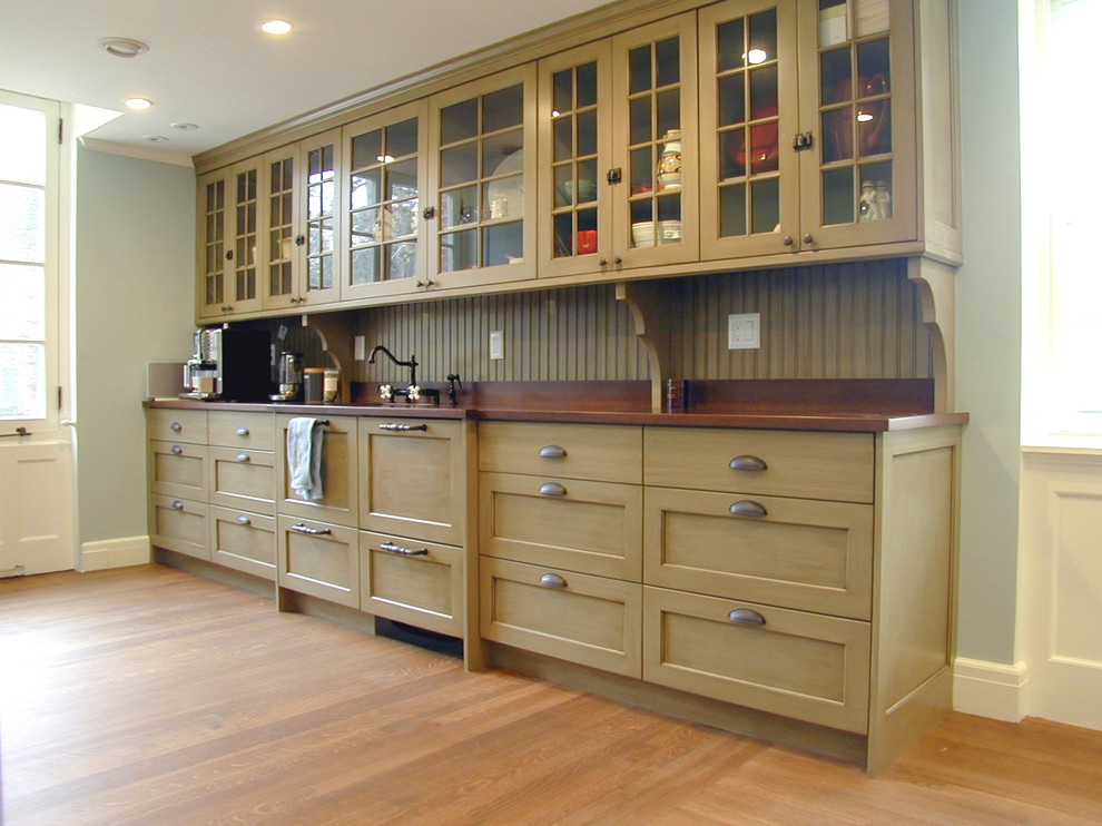Photo of a mid-sized arts and crafts single-wall kitchen in Boston with an undermount sink, recessed-panel cabinets, beige cabinets, wood benchtops, green splashback, timber splashback, light hardwood floors, no island and brown floor.