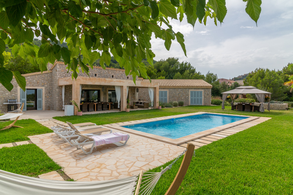 Foto de piscina campestre grande rectangular en patio trasero