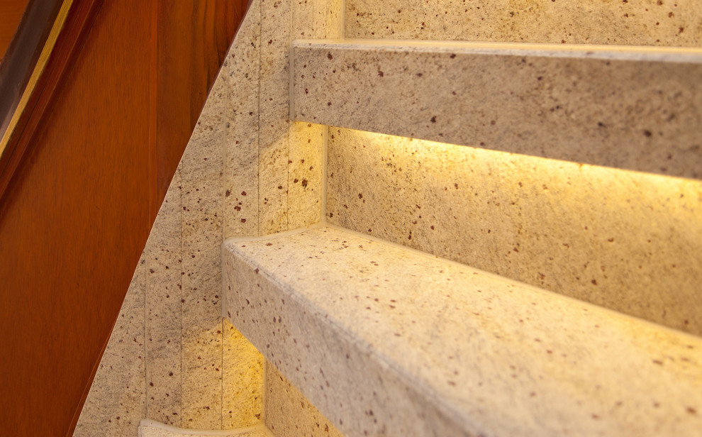 Design ideas for a small country marble curved staircase in Dortmund with marble risers and wood railing.