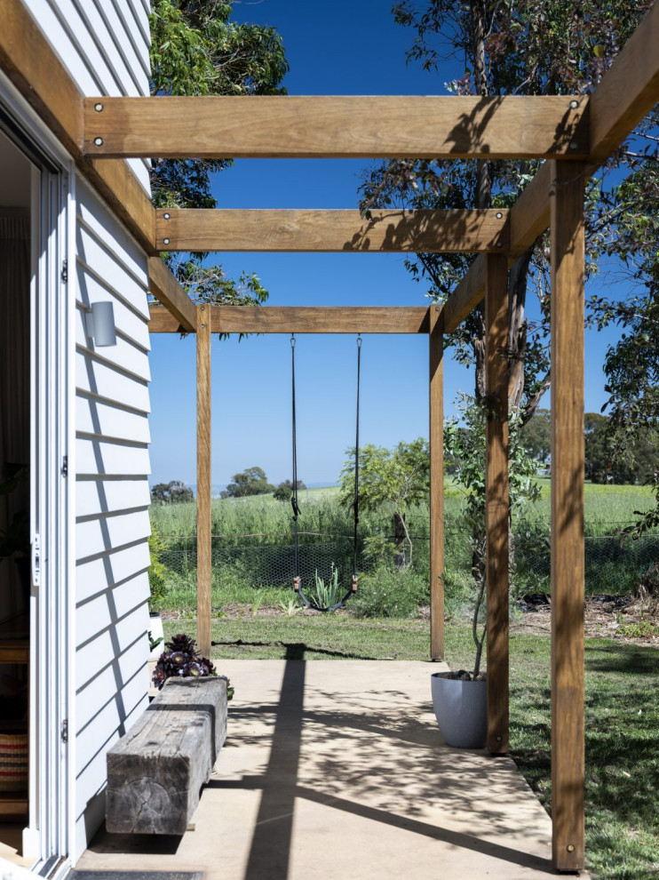 Photo of a mid-sized backyard patio in Other with concrete slab and a pergola.
