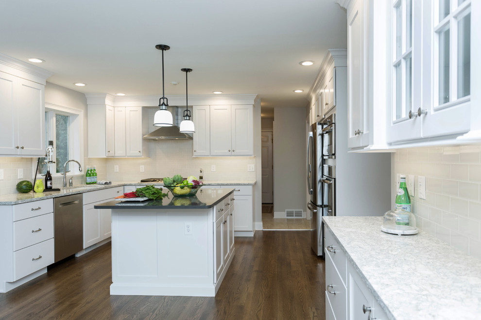Example of a mid-sized transitional u-shaped dark wood floor enclosed kitchen design in Boston with an undermount sink, recessed-panel cabinets, white cabinets, quartz countertops, gray backsplash, subway tile backsplash, stainless steel appliances and an island